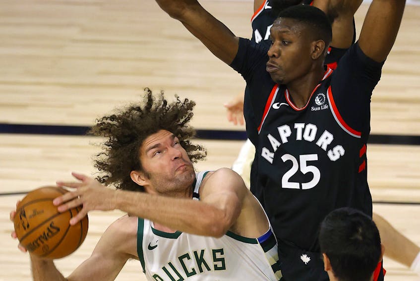 Bucks centre Robin Lopez is pressured by the Raptors’ Chris Boucher during Toronto’s win on Monday night. The Raptors are 5-1 since returning to play. 