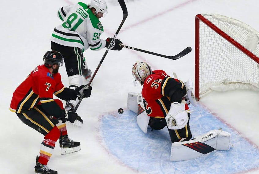 Cam Talbot #39 of the Calgary Flames stops a shot against Tyler Seguin #91 of the Dallas Stars as TJ Brodie #7 defends during the third period in Game 3 of the Western Conference First Round during the 2020 NHL Stanley Cup Playoffs at Rogers Place on August 14, 2020.