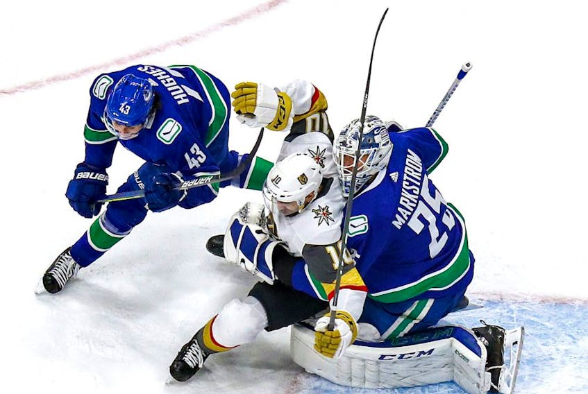 Nicolas Roy #10 of the Vegas Golden Knights is checked in Jacob Markstrom #25 by Quinn Hughes #43 of the Vancouver Canucks during the first period in Game Three of the Western Conference Second Round during the 2020 NHL Stanley Cup Playoffs at Rogers Place on August 29, 2020.