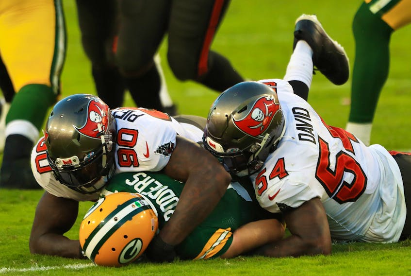 Jason Pierre-Paul and Lavonte David  of the Tampa Bay Buccaneers sack Aaron Rodgers of the Green Bay Packers during the third quarter at Raymond James Stadium on October 18, 2020. 