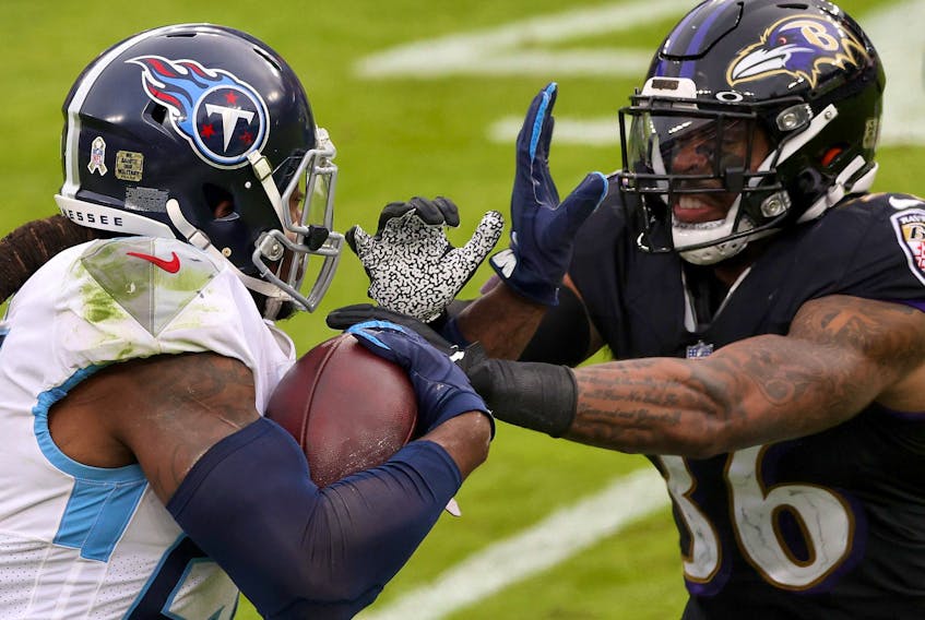 Running back Derrick Henry of the Tennessee Titans stiff arms strong safety Chuck Clark #36 of the Baltimore Ravens in the second half on Sunday. 
