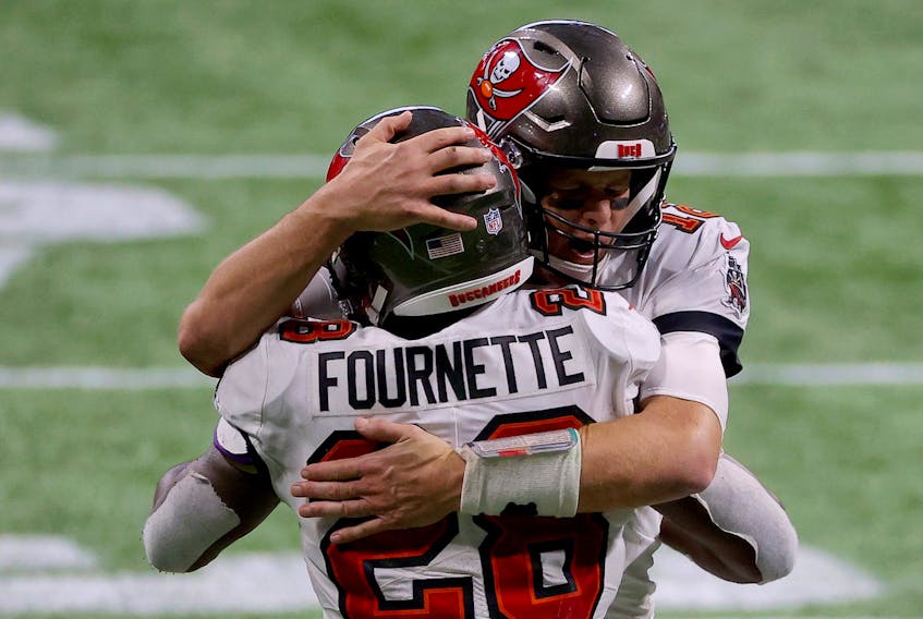 Tom Brady of the Tampa Bay Buccaneers celebrates with Leonard Fournette after a first down against the Atlanta Falcons during the fourth quarter in the game at Mercedes-Benz Stadium on December 20, 2020 in Atlanta, Georgia. 