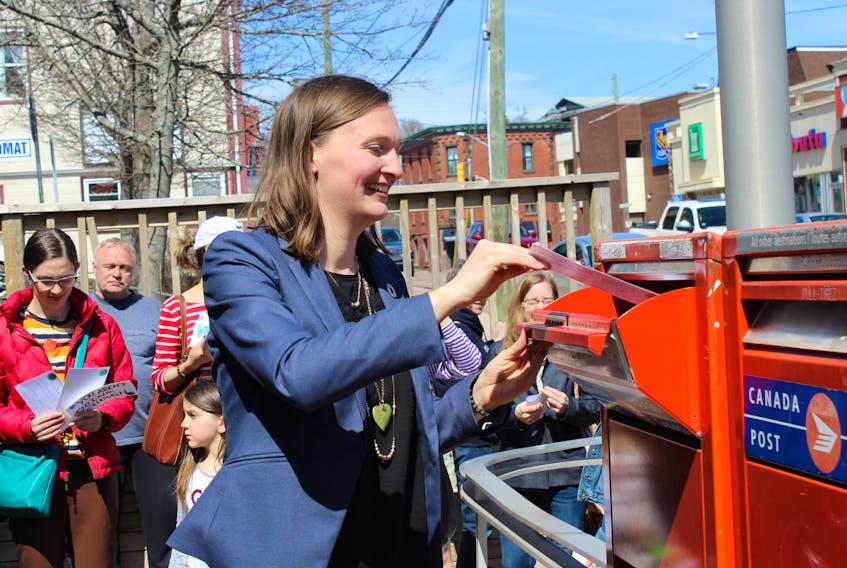 Memramcook-Tantramar MLA Megan Mitton, shown here during the recent student climate rally in Sackville mailing a postcard to the federal government demanding a new climate policy, has introduced a motion in the provincial Legislature to declare a climate emergency in New Brunswick.