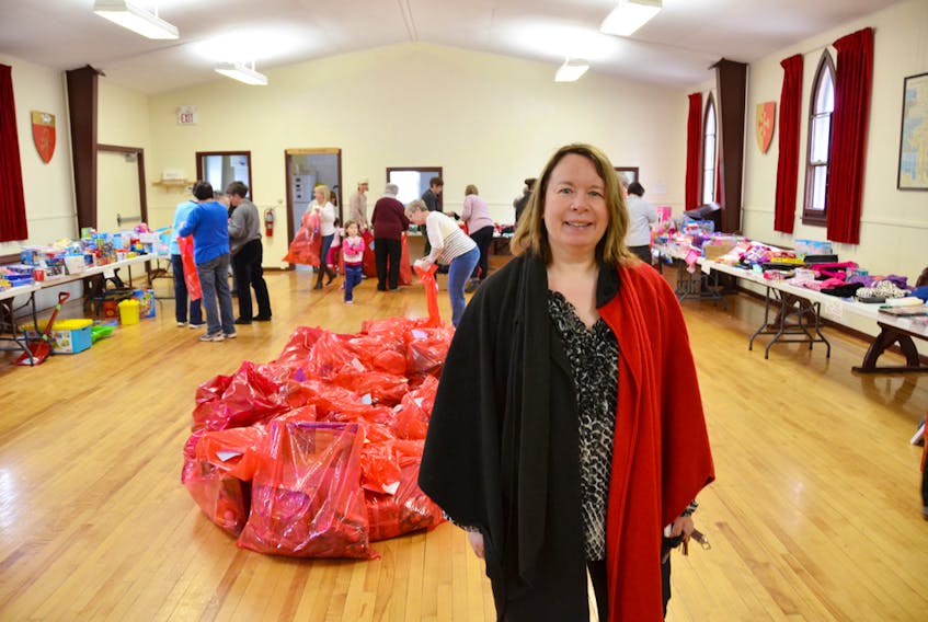 Elizabeth Wells is shown in the foreground as volunteers sort and bag donations during last year’s Christmas Cheer program packing day.