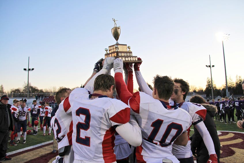 The Tantramar football Titans celebrate after winning the provincial championship Saturday afternoon in Sackville. The team defeated the Moncton Purple Knights 24-14 to capture the title for the third year in a row.
