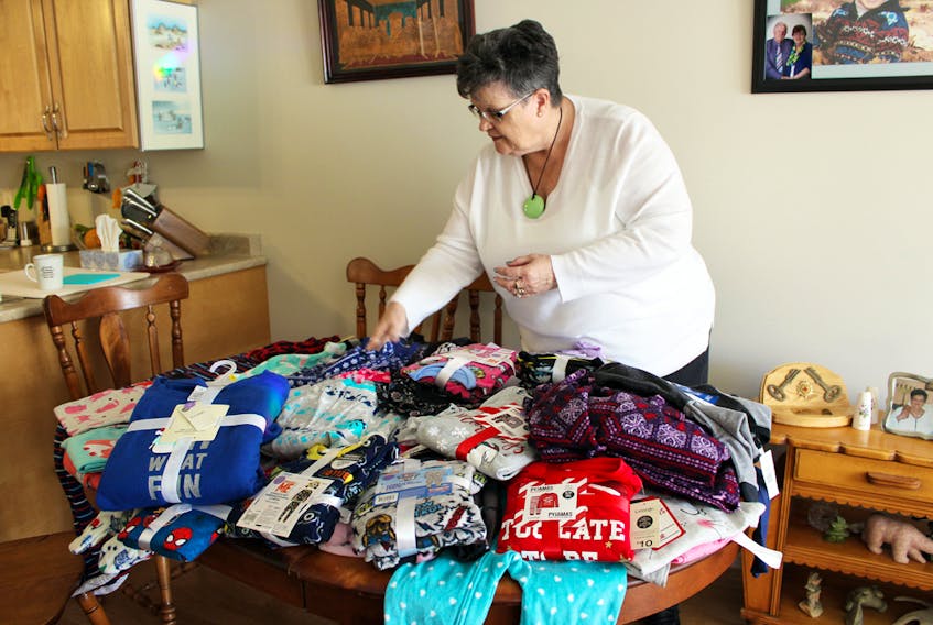 Pat Cormier sorts through the many sets of pyjamas she has already collected for the Sackville Christmas Cheer program this year. Cormier says she is about halfway to reaching her goal and is hoping others will rise to the call and donate to the pyjama drive.