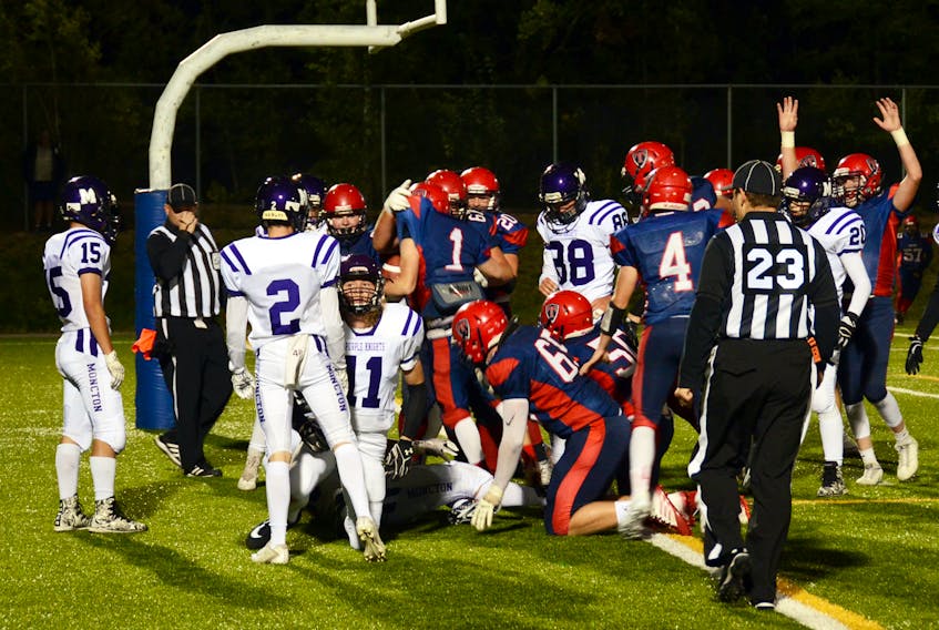 Second year Tantramar Titan Elliot Hicks is picked up by his team mates as they celebrate his drive into the endzone from the Purple Knights’ one-yard line late in Friday’s game.