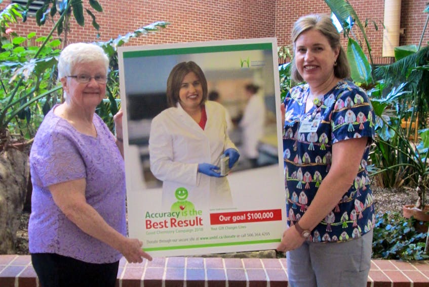 The Sackville Memorial Hospital Foundation’s Accuracy is the Best Result Good Chemistry Campaign chair Pat Estabrooks, left, and Joanne Smith, medical lab technologist at the local hospital display one of the posters promoting this year’s fundraiser.