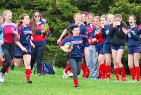 With her teammates proudly cheering her on, Sierra Holmes, a Grade 9 student at Tantramar Regional High School with Down Syndrome, runs down the field to score her first try during last Thursday’s final home game of the season for the TRHS women’s rugby Titans. SCOTT HEMS PHOTO