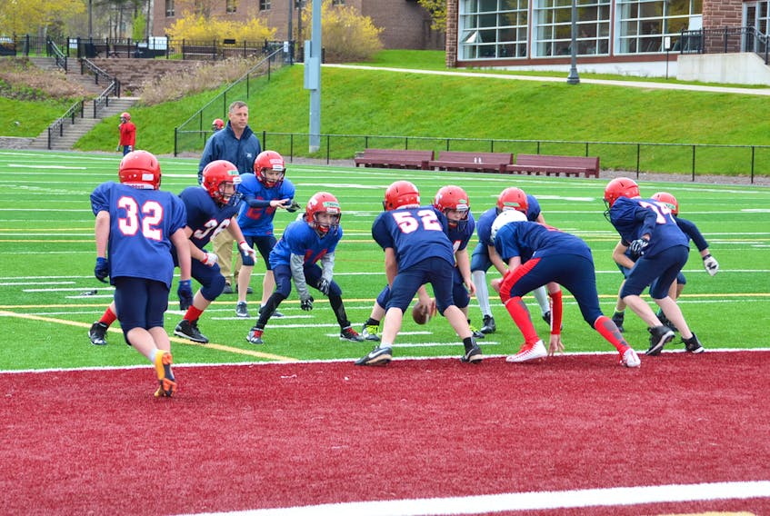 Local minor football players take part in last year’s spring camp under the watchful eye of past-president Tim Cormier.