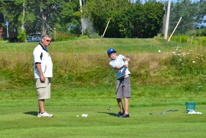 Bob Milner, head instructor of Sackville’s junior golf program, offers some tips to a young golfer during a practice session on Monday morning.