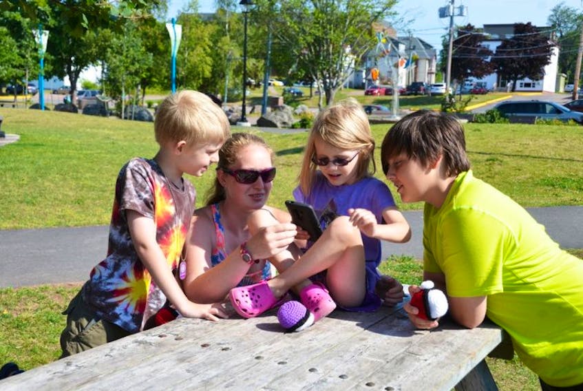 Left to right, Ethan Wells, Patricia Wells, Alexis Hicks and Texas Hicks search for Pokemon in the Bill Johnstone Memorial Park in downtown Sackville. KATIE TOWER – SACKVILLE TRIBUNE-POST