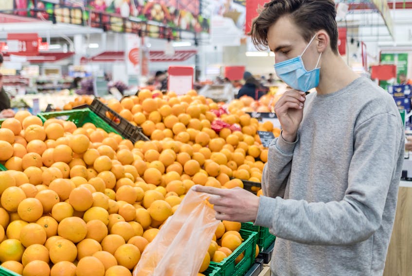 A man wearing a medical masks shops for groceries.
