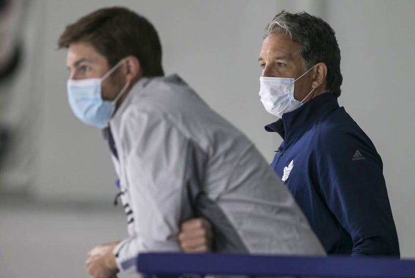 Brendan Shanahan and Kyle Dubas take in Leafs practice on Monday.