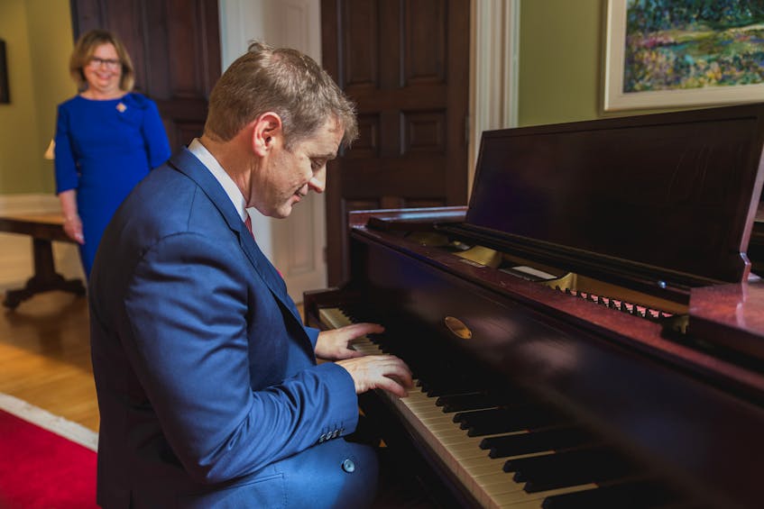Premier Andrew Furey plays the piano as Lt. Gov. Judy Foote looks on during a break in the official proceedings at Government House in St. John's on Wednesday. — Contributed
