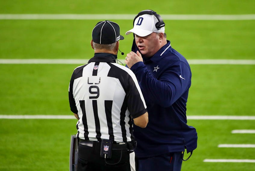Dallas Cowboys head coach Mike McCarthy talks with line judge Mark Perlman during Sunday night's game against the Rams.