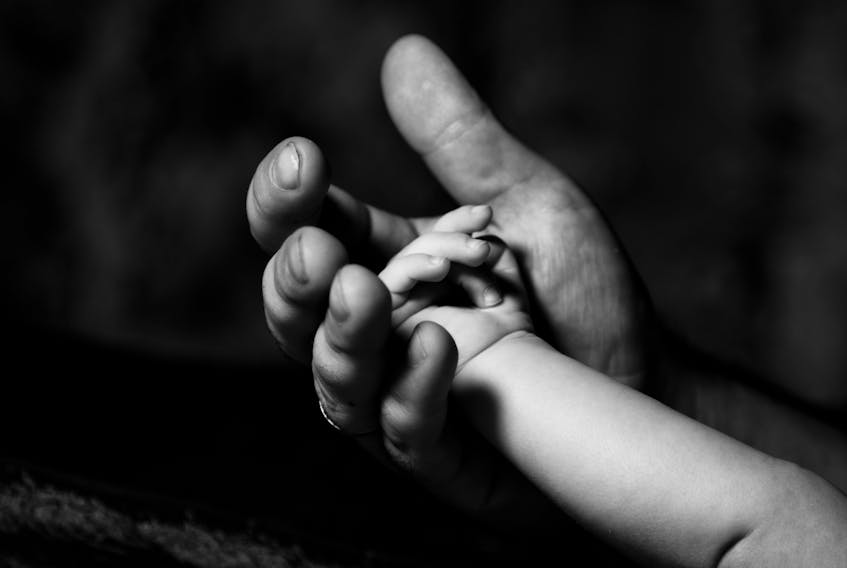 An adult holding a young person's hand for use with child custody stories.