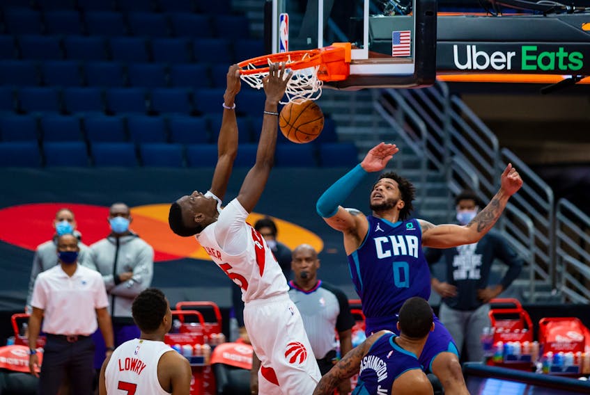 Toronto Raptors forward Chris Boucher  dunks over Charlotte Hornets forward Miles Bridges on Thursday.