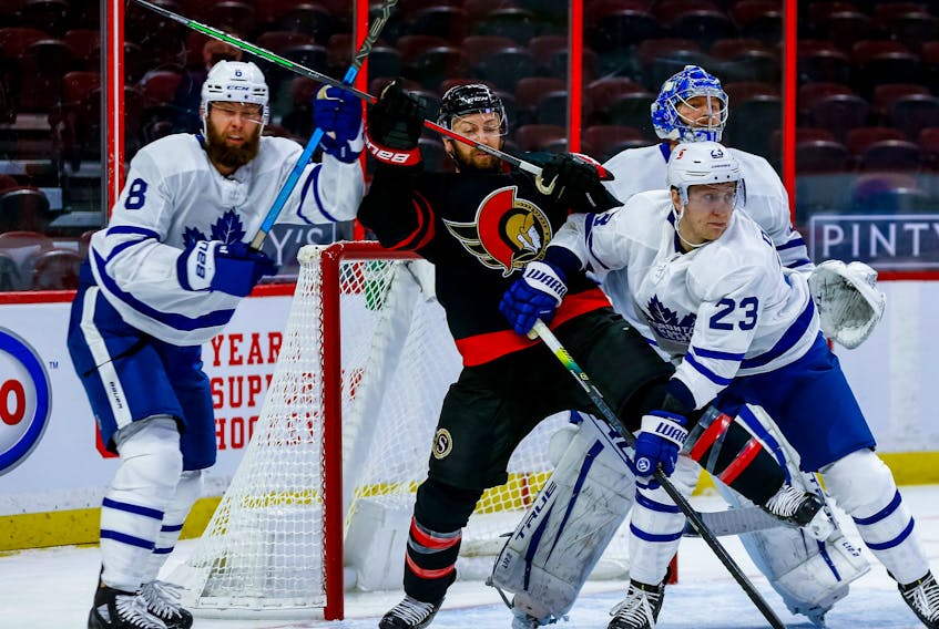Ottawa Senators centre Derek Stepan  battles with Toronto Maple Leafs defenceman Jake Muzzin (left) and defenseman Travis Dermott in front of goaltender Frederik Andersen on Friday night.