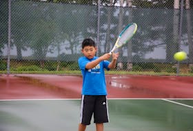Yuheng Fu, 8, plays tennis at Victoria Park in Charlottetown recently.