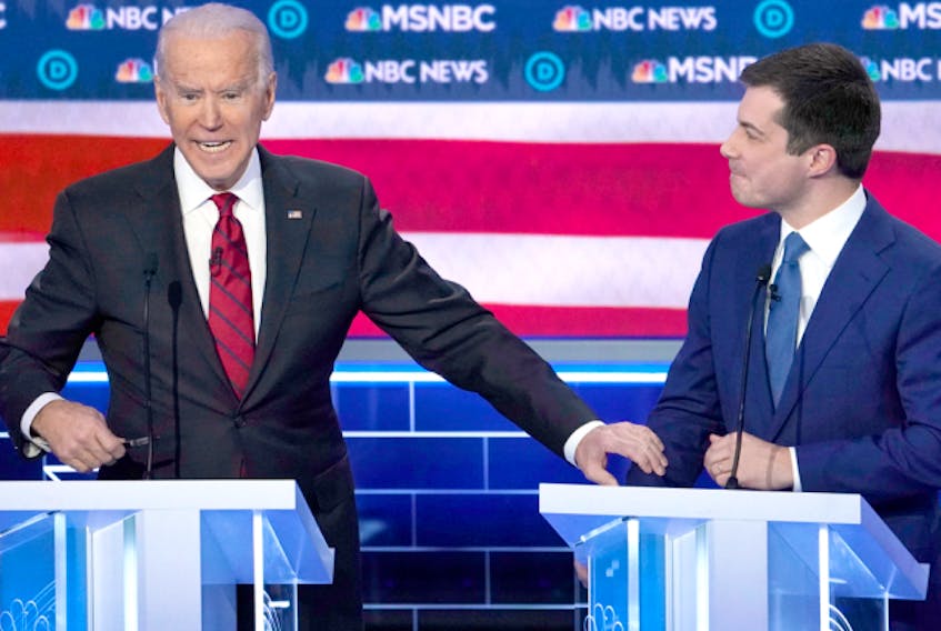  Joe Biden grabs the arm of Pete Buttigieg as he speaks during the ninth Democratic U.S. presidential candidates debate in Las Vegas, Nevada, U.S., February 19, 2020.