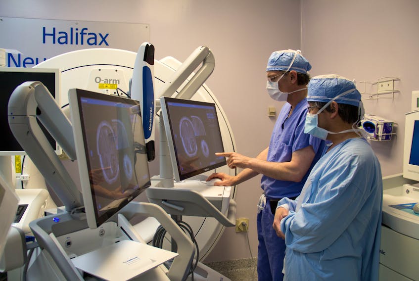 David Clarke, head of neurosurgery at Dalhousie University and the Nova Scotia Health Authority, and surgery imaging specialist Murray Hong, review the plans for a robotic surgery. - Contributed