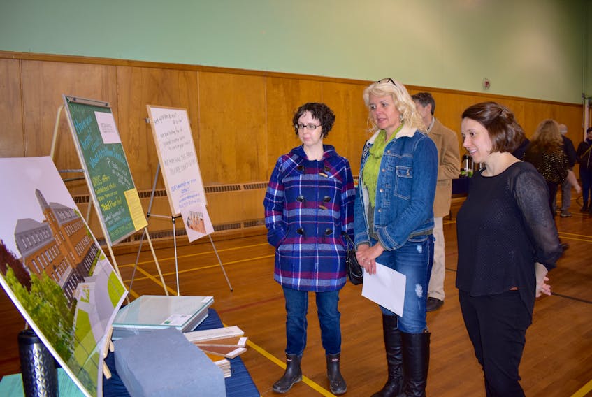 Erika Shea, right, vice-president of development for New Dawn Enterprises, shows Carole Lee Boutilier, middle, and Donelda MacDonald plans for the new Cape Breton Centre for Arts, Culture and Innovation during an open house at the former Holy Angels High School in Sydney. The new art centre is expected to open its doors at the Holy Angels Convent in summer 2019.