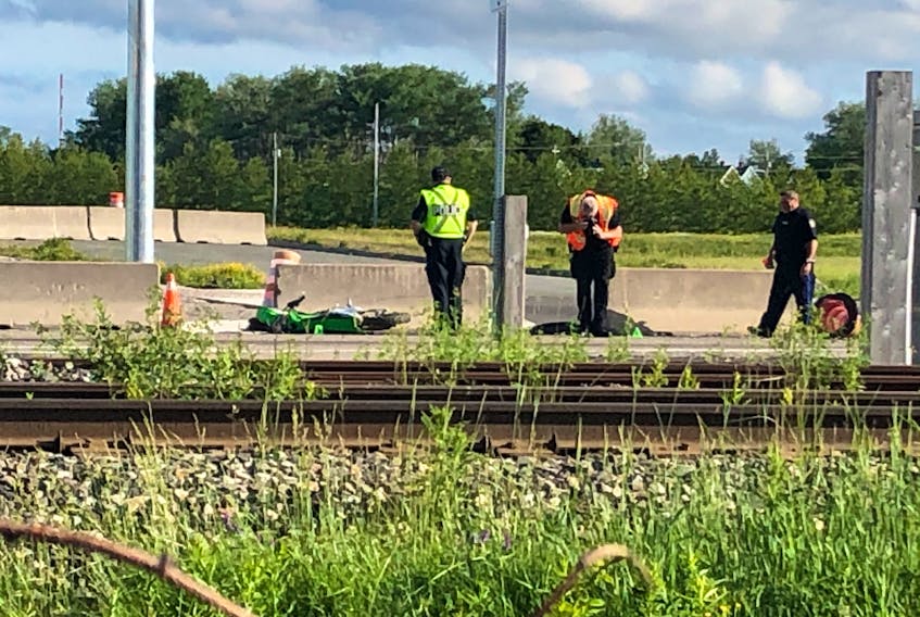 Cape Breton Regional Police officers are shown investigating an accident near the intersection of Spar Road and Lingan Road in Sydney on Friday. The accident is believed to have involved a green dirt bike and a burgundy truck.