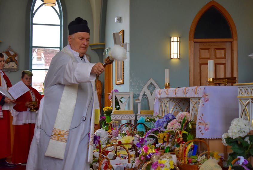 Father Richard Philiposki of St. Mary's Polish Parish blesses baskets during the 105th annual Blessing of the Easter Baskets and Easter Foods at the Whitney Pier church on Saturday. Close to 50 baskets were blessed during the event.