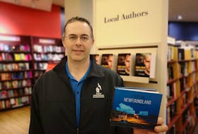 St. John’s based photographer, Michael Winsor, with his new book of photography, ‘Lost in Newfoundland.’ - Andrew Waterman/The Telegram
