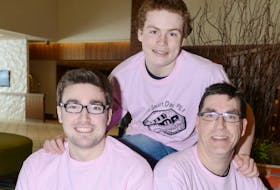 Travis Price, front left, the man behind the international Pink Shirt Day, poses with Joe Killorn and his son Dalton, both supporters of Price's anti-bullying campaign. Price is in Prince Edward Island this week to spread his peaceful message to students.