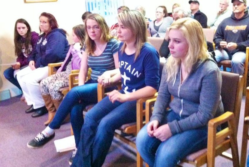 Ann Marie King, centre, wearing Captain shirt, sitting with her friends Lydia Acorn, left, and Kyla Mackenzie, right, led the packed presentation at Montague Town Hall Monday night requesting support for a youth centre in the Kings County town.