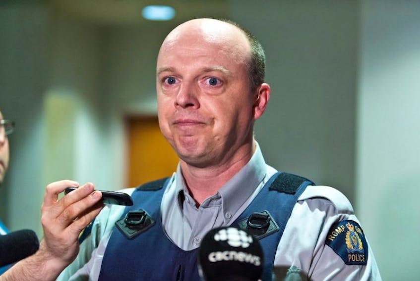 RCMP officer Damien Theriault holds back tears while addressing the media during a press conference at City Hall in Moncton, N.B., on Wednesday June 4, 2014.