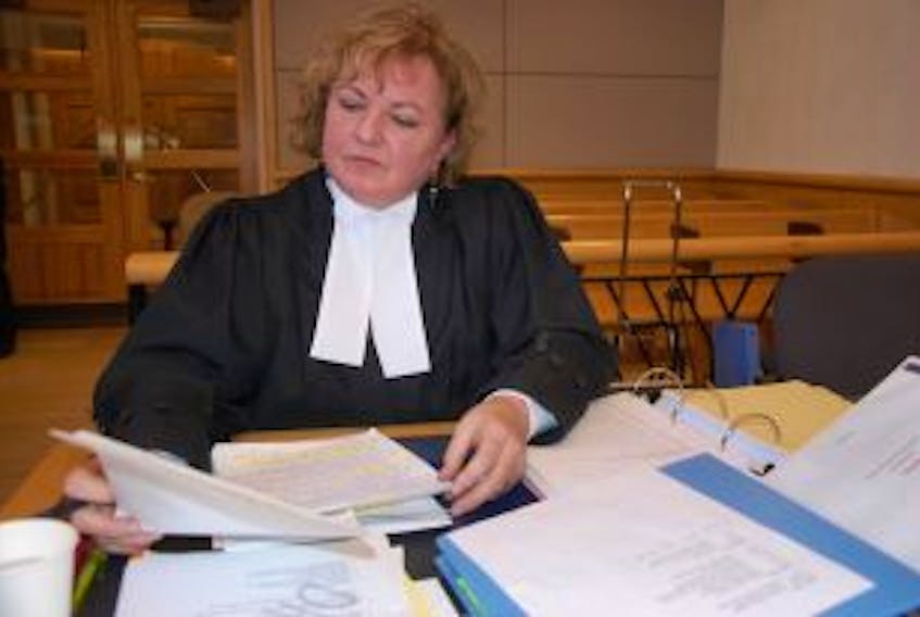 ['Defence lawyer Trish Cheverie reviews notes during a break in the jury trial of a teen charged with second-degree murder in the stabbing death of 45-year-old Kent David Gallant of Charlottetown on July 11, 2014.']