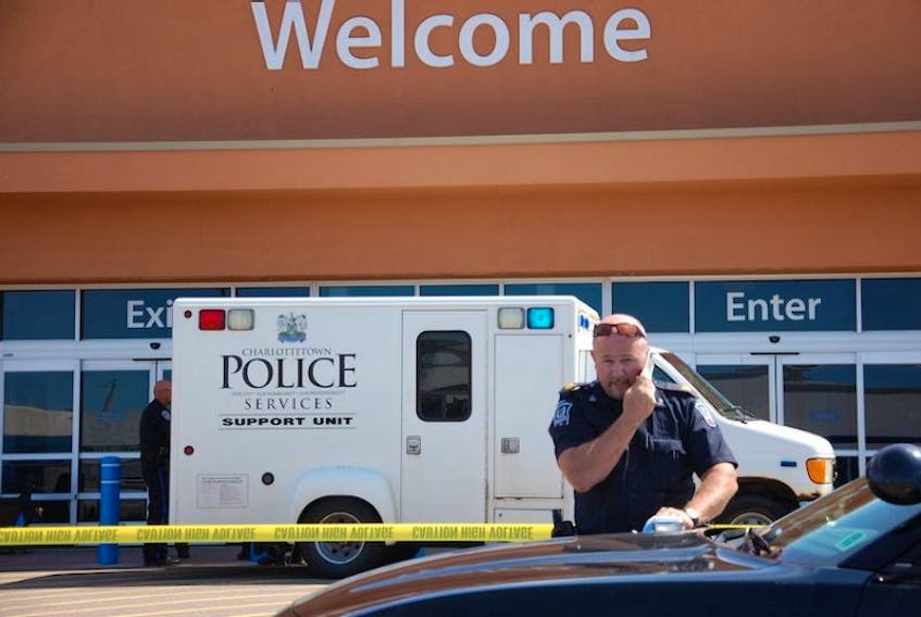 Charlottetown police Sgt. Dave Pound speaks on the phone while the Walmart store is taped off behind him during a bomb scare at the retailer Tuesday in Charlottetown.