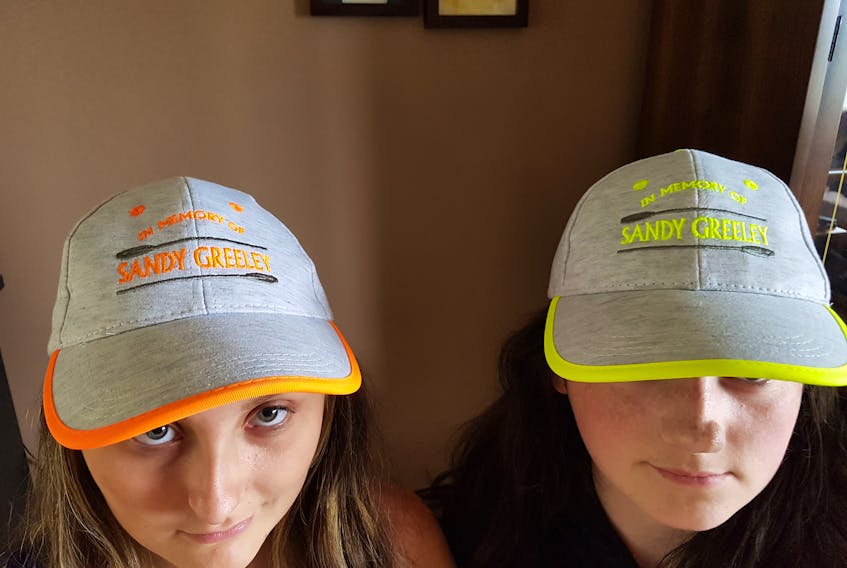 Samantha Elens (left) and Claire Neary of the Pyramid Construction female juvenile rowing team wear hats honouring Elens’ grandfather, Royal St. Johns Regatta Hall of Famer Sandy Greeley, who died earlier this year at the age of 76. The hats were the idea of Greeley’s daughter, Gina Elens, who originally bought 14 caps for the members of two age-group rowing teams which include the grandchildren of Greeley, who was synonymous with rowing in Portugal Cove. However, they proved to be so popular with rowers and others associated the Regatta that she has ordered 10 dozen more hats to be imprinted by Ultagraphics. Samatha Elens is one of five of Greeley’s grandchildren who are preparing to row in the St. John’s regatta this year. The other are Jessica Greeley of the Pyramid Construction team, Dennis Greeley of the Kids Campus male squirt entry; Bradley White of the Wade’s Excavating senior men’s team and Samantha Hynes of the Harvey’s Home Heating senior women’s crew. As well, Sandy Greeley’s two sons are coxswains  — Kevin with Pyramix Construction and Robert with Kids Campus. Kevin Greeley is also part of the Wade’s Excavating team. — Submitted