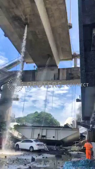 A view of debris and the collapsed Nanfang'ao Bridge is seen after a typhoon hit Su'ao in Yilan county, Taiwan, Oct. 1, 2019, in this still image from video obtained via social media. Xinmei Live Seafood via Reuters
