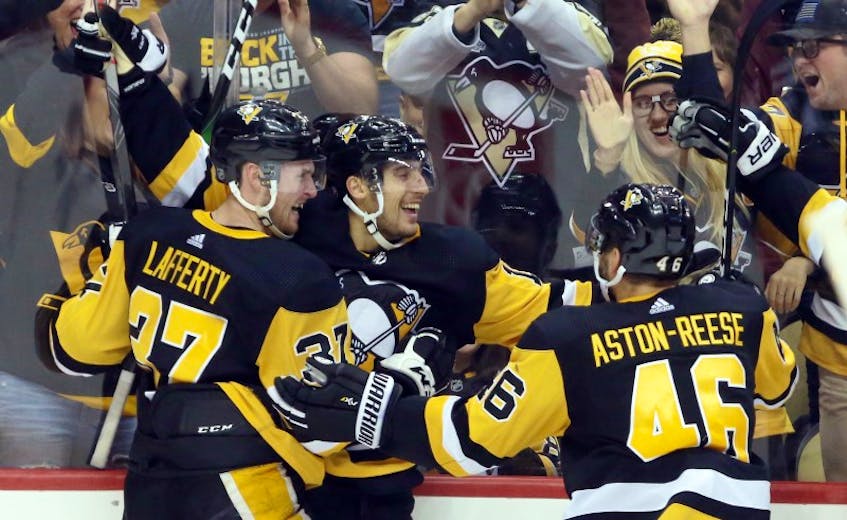 Pittsburgh Penguins left wing Brandon Tanev (middle) celebrates his game winning goal with center Sam Lafferty (37) and center Zach Aston-Reese (46) against the Colorado Avalanche in overtime at PPG PAINTS Arena. Pittsburgh won 3-2 in overtime. Mandatory Credit: Charles LeClaire-USA TODAY Sports