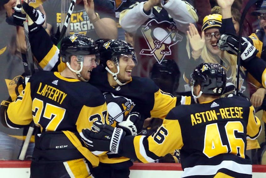 Pittsburgh Penguins left wing Brandon Tanev (middle) celebrates his game winning goal with center Sam Lafferty (37) and center Zach Aston-Reese (46) against the Colorado Avalanche in overtime at PPG PAINTS Arena. Pittsburgh won 3-2 in overtime. Mandatory Credit: Charles LeClaire-USA TODAY Sports