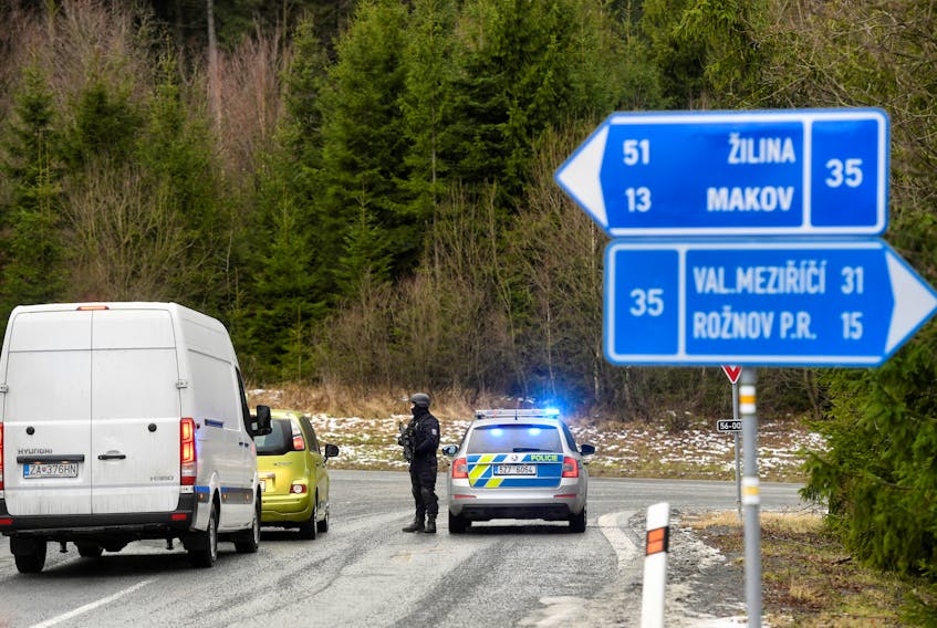 A police officer is seen at a road blockade, as police checks cars after a shooting at Ostrava's University Hospital, near the Slovak-Czech border crossing in Bila, Czech Republic, Dec. 10, 2019.