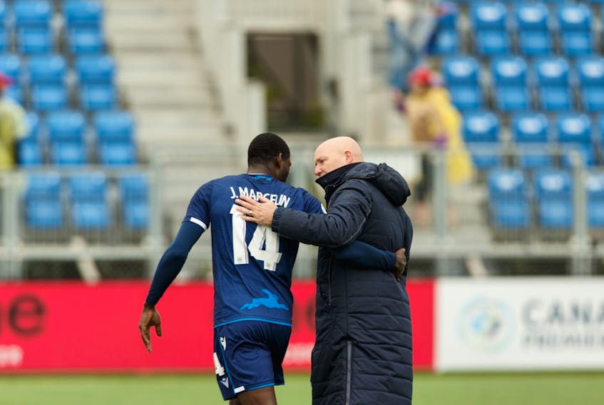 FC Edmonton's head coach Jeff Paulus (right) speaks with James Marcelin (14) after the team beat the HFX Wanderers FC 2-0 during Canada Premier League soccer action at Clarke Stadium in this file photo from July 1, 2019.