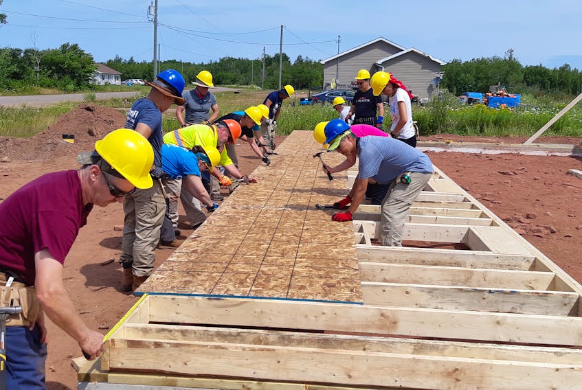 The team from Global Village works on a new Habitat for Humanity home in Lennox Island.