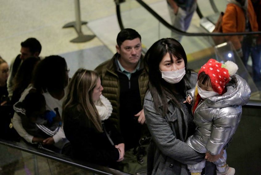 Travellers wearing masks arrive on a direct flight from China to at Seattle-Tacoma International Airport in Seattle, Washington on Friday (Jan. 23, 2020). One person has tested positive for coronavirus so far in the United States.