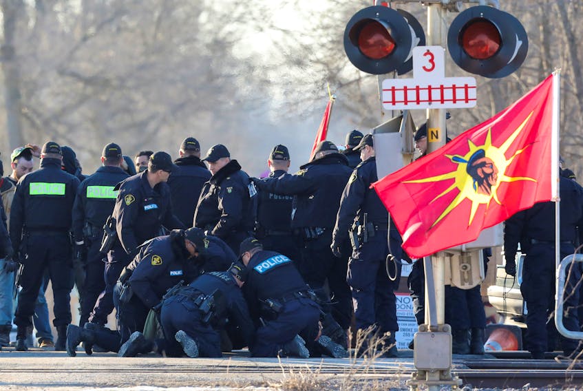 Police officers make an arrest during a raid on a Tyendinaga Mohawk Territory camp next to a railway crossing in Tyendinaga, Ont. Teck Resources withdrew plans for a $20 billion oilsands mine in Alberta partly due to concerns about future blockades. REUTERS