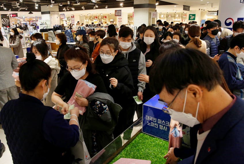 People wearing masks to prevent contracting the coronavirus wait in line to buy masks at a department store in Seoul, South Korea February 27, 2020.
