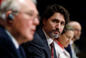 Prime Minister Justin Trudeau listens to Public Safety Minister Bill Blair during a news conference on Parliament Hill in Ottawa on Friday, May 1, 2020.