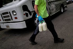A man delivers milk at Capitol Hill as COVID-19 continues to spread nationwide and public anxiety lingering in grocery stores has created a new surge of interest in home food deliveries, in Washington, U.S., May 18, 2020.
