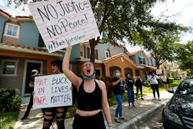 Protesters react to the news of the arrest of former Minneapolis police officer Derek Chauvin, who was recorded with his knee on the neck of African-American man George Floyd before his death, outside his Florida home in the Windermere neighbourhood of Orlando, Fla., May 29, 2020. - Scott Audette / Reuters