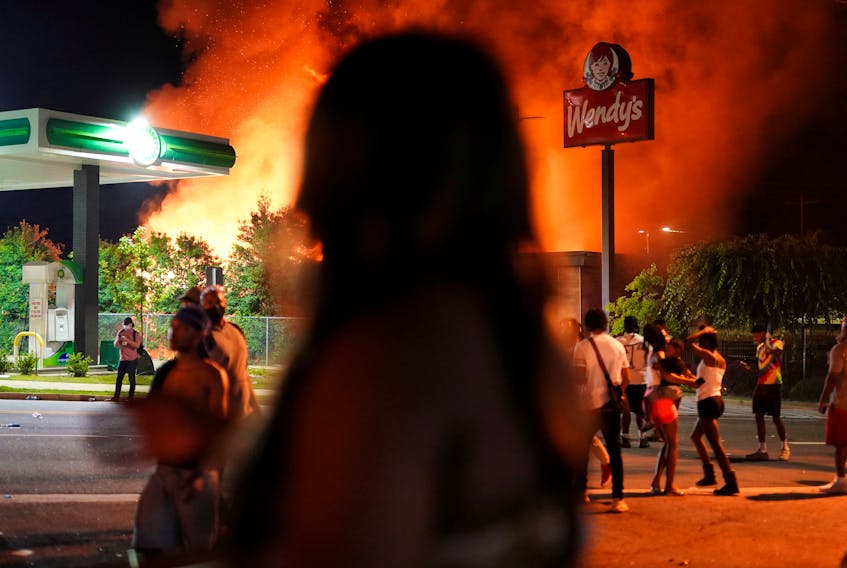 People watch as a Wendy’s burns after a rally  June 13, 2020 against racial inequality and the police shooting death of Rayshard Brooks, in Atlanta, Georgia. Elijah Nouvelage / Reuters