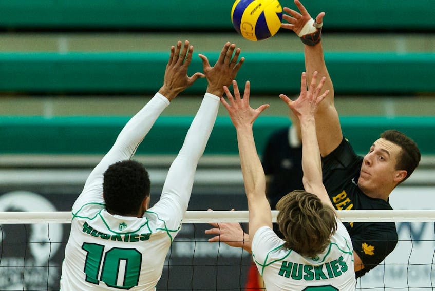 University of Alberta Golden Bears' Jackson Kennedy (8) spikes the ball past University of Saskatchewan Huskies Daven Pascal (10) and Connor Murray (2) during Canada West action at the Saville Community Sports Centre on Thursday, Feb. 20, 2020.